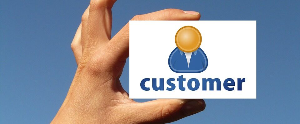 Hand holding a white card with a customer icon on it - What is to Improve Quality
