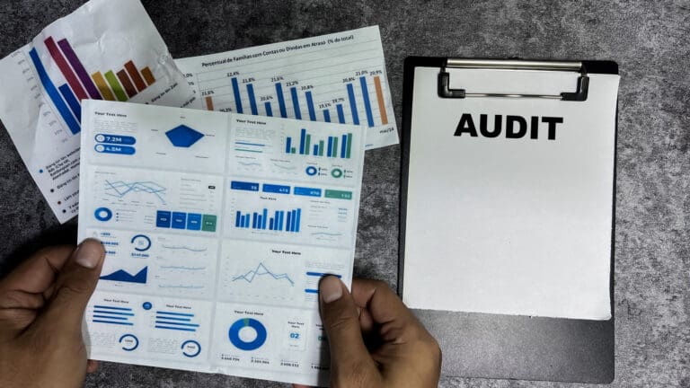 Audit text written on clipboard with charts on a woodedn table being reviewed by a business owner - Benefits of an Internal Audit