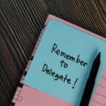 Remember to Delegate Task Sticker Memo in Notebook on a Desk