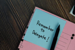 Remember to Delegate Task Sticker Memo in Notebook on a Desk