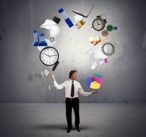 Businessman juggling numerous business objects including a clock - Best Time Management Tips
