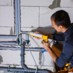 Male Plumber repairs pipes in the toilet - How to Treat the Role of a Small Business Owner