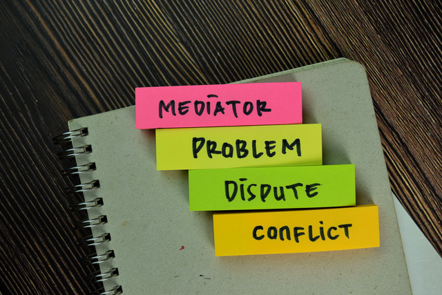 mediator, problem, dispute, conflict write on sticky notes isolated on wooden table.