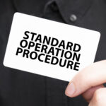 businessman holding a card with text standard operation procedure, business - How to Create an SOP Document