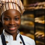 A black business owner woman with a warm smile standing in a bakery - How to Treat the Role of a Small Business Owner