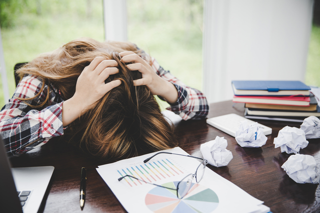 young-frustrated-exhausted-woman-with-head-down-on-table - A Toxic Work Environment and Mental Health