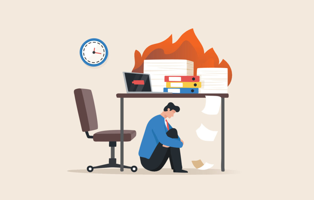 burn out syndrome - a young man or employee sits under the table -