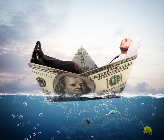 man-relaxing-in-a-boat-made-of-a-dollar-bill-cash-flow-concept - what is cash flow in business